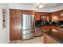 Stainless steel appliances and ample wood cabinetry in this kitchen at 4950 N Miller Rd # 130, Scottsdale, AZ 85251