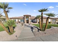 Charming single-story home featuring an intricate brick facade, palm trees and well-maintained landscaping at 5345 E Mclellan Rd # 89, Mesa, AZ 85205
