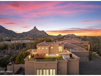 Rooftop lounge with comfortable seating, fire pit, and stunning mountain views at sunset at 10102 E Saddle Horn Trl, Scottsdale, AZ 85255