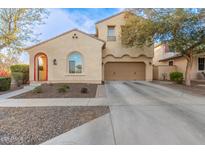 Two-story house with tan exterior, red-tiled accents, and a two-car garage at 13608 N 150Th Ln, Surprise, AZ 85379