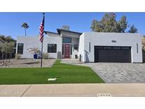 Modern home with red front door, landscaped lawn, and paved driveway at 14426 N 39Th Way, Phoenix, AZ 85032