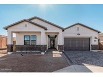 Stunning ranch-style home with a modern gray-toned garage door and brick accents at 2553 E Virginia Cir, Mesa, AZ 85213