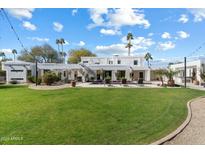 Expansive backyard features a manicured lawn, sparkling pool, and outdoor seating perfect for entertaining at 6039 E Laurel Ln, Scottsdale, AZ 85254