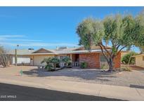 Brick ranch house with a two-car garage and nicely landscaped front yard at 13226 W Mesa Verde Dr, Sun City West, AZ 85375