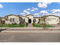 Stunning single-story home with manicured lawn, decorative stone and a welcoming arched entryway at 20456 E Camina Buena Vis, Queen Creek, AZ 85142