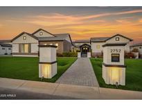 Stunning modern farmhouse with lush lawn, illuminated walkway, and charming mailbox post at sunset at 2752 E Pelican Ct, Gilbert, AZ 85297