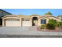 House exterior featuring a three-car garage and well-manicured landscaping at 29606 N 21 Dr, Phoenix, AZ 85085