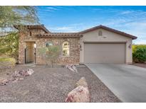 Front view of a charming one-story home with stone accents and a two-car garage at 29762 N 69Th Ln, Peoria, AZ 85383