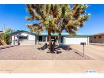 Charming single-story home with gravel landscaping, mature tree, and white two-car garage at 6058 E El Paso St, Mesa, AZ 85205