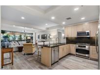 Modern kitchen features stainless steel appliances, granite countertops, and an open design to the living area at 7117 E Rancho Vista Dr # 3010, Scottsdale, AZ 85251