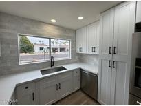 Modern kitchen with white cabinets, quartz countertops, and stainless steel appliances at 7663 E Coolidge St, Scottsdale, AZ 85251