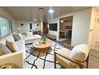 Comfortable living room featuring a white couch, round coffee table, and a graphic rug, with views of the dining area at 8103 E Southern Ave # 84, Mesa, AZ 85209