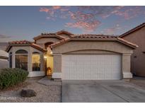 Tan house with a white garage door and landscaped yard at 9765 W Pontiac Dr, Peoria, AZ 85382