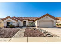 Single-story home with tile roof, landscaped yard, and two-car garage at 21410 N 157Th Ave, Sun City West, AZ 85375