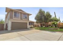 Two-story home featuring an attached garage, well-maintained lawn, and mature tree in a quiet neighborhood at 4615 W Boston St, Chandler, AZ 85226