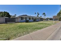 Charming single-story home with a lush green lawn and mature palm trees offering nice curb appeal at 811 W Northern Ave, Phoenix, AZ 85021