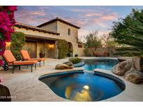 Stunning backyard pool and spa area with natural rock accents, lush landscaping, and a charming stone building at 8260 E Sunset View Dr, Gold Canyon, AZ 85118