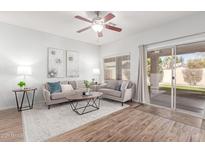 Bright living room featuring wood floors, neutral furniture, and a sliding glass door to the backyard at 846 W Kroll Ave, Gilbert, AZ 85233