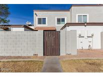 Back exterior view of townhome with private gated entry and small yard at 954 E Diamond Dr, Tempe, AZ 85283