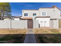 Back exterior view of townhome with private gated entry and small patio at 954 E Diamond Dr, Tempe, AZ 85283