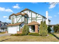 Two-story house with a white exterior, green accents, and a brick facade at 1112 W Citation Dr, Chandler, AZ 85224