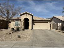 One-story house with tan exterior, tile roof, and a two-car garage at 11810 W Belmont Dr, Avondale, AZ 85323