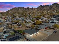 Aerial view of a single-story house with a pool, solar panels, and mountain backdrop at 1510 E Mission Ln, Phoenix, AZ 85020