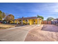 Charming yellow ranch home with a spacious front yard and covered porch at 1555 W 7Th Pl, Mesa, AZ 85201