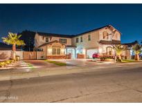 Two-story house with a red car parked in the garage at night at 16846 W Hilton Ave, Goodyear, AZ 85338