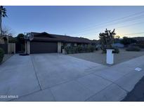 Ranch-style home with a two-car garage and landscaped front yard at 2401 E Christy Dr, Phoenix, AZ 85028