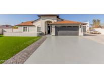 House exterior featuring a two-car garage and nicely landscaped lawn at 3450 N 67Th Dr, Phoenix, AZ 85033