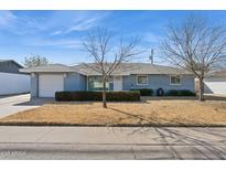 Charming ranch home with a well-manicured lawn and attached garage at 3813 W Glenn Dr, Phoenix, AZ 85051