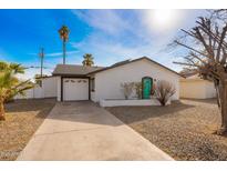 Cute ranch home with a teal door, two-car garage, and a gravel driveway at 6201 W Maryland Ave, Glendale, AZ 85301