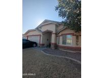 Single-story home with a two-car garage and landscaped front yard at 7417 W Park St, Laveen, AZ 85339