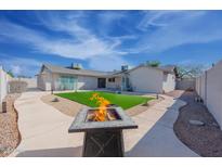 Landscaped backyard with artificial turf and fire pit at 2016 E Pegasus Dr, Tempe, AZ 85283
