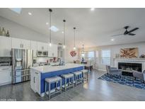 Bright open kitchen with stainless appliances, white cabinetry, pendant lights and island with seating, flowing into the living space at 5507 E Grandview Rd, Scottsdale, AZ 85254