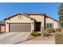 Charming single-story home with a two-car garage and a well-manicured front yard with desert landscaping at 17532 W Bajada Rd, Surprise, AZ 85387