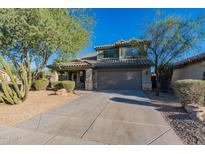 Two-story house with a large driveway and landscaping at 2438 W Gambit Trl, Phoenix, AZ 85085