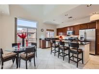 Bright kitchen features stainless steel appliances, granite counters, and a breakfast bar adjacent to a glass-top dining table at 3935 E Rough Rider Rd # 1191, Phoenix, AZ 85050