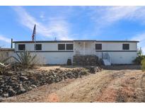 White single-story home with stone accents and a spacious yard at 49201 N 24Th Ave, New River, AZ 85087