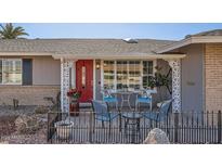 Inviting front porch with red door and comfortable seating area at 9613 W Long Hills Dr, Sun City, AZ 85351