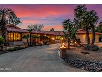 Beautiful desert home exterior at sunset, showcasing a large driveway and landscaping at 22206 N La Senda Dr, Scottsdale, AZ 85255