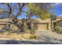 Desert landscape surrounds this single-story home with a two-car garage at 6788 E Nightingale Star Cir, Scottsdale, AZ 85266