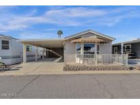 Tan colored manufactured home with carport and small fenced patio at 8700 E University Dr # 2216, Mesa, AZ 85207