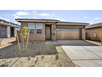 Charming single-story home featuring a stone-accented facade, gravel landscaping, and a two-car garage at 17299 W Desert Sage Dr, Goodyear, AZ 85338