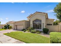 Tan two-story home with a tile roof, landscaping, and a two-car garage at 7439 E Beryl Ave, Scottsdale, AZ 85258