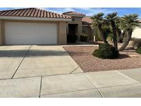 Single-story home with a two-car garage and desert landscaping at 13015 W Caraway Dr, Sun City West, AZ 85375