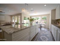 Bright kitchen features granite counters, a large island with seating, and views to the living room and backyard at 2073 E Wildhorse Dr, Chandler, AZ 85286