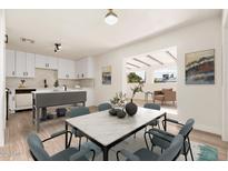 Bright dining area featuring modern table set, hardwood floors, and open flow to the updated kitchen at 2227 W Paradise Dr, Phoenix, AZ 85029