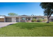 Charming single-story home featuring a well-maintained lawn, brick accents, and attached garage at 2527 N 69Th Pl, Scottsdale, AZ 85257